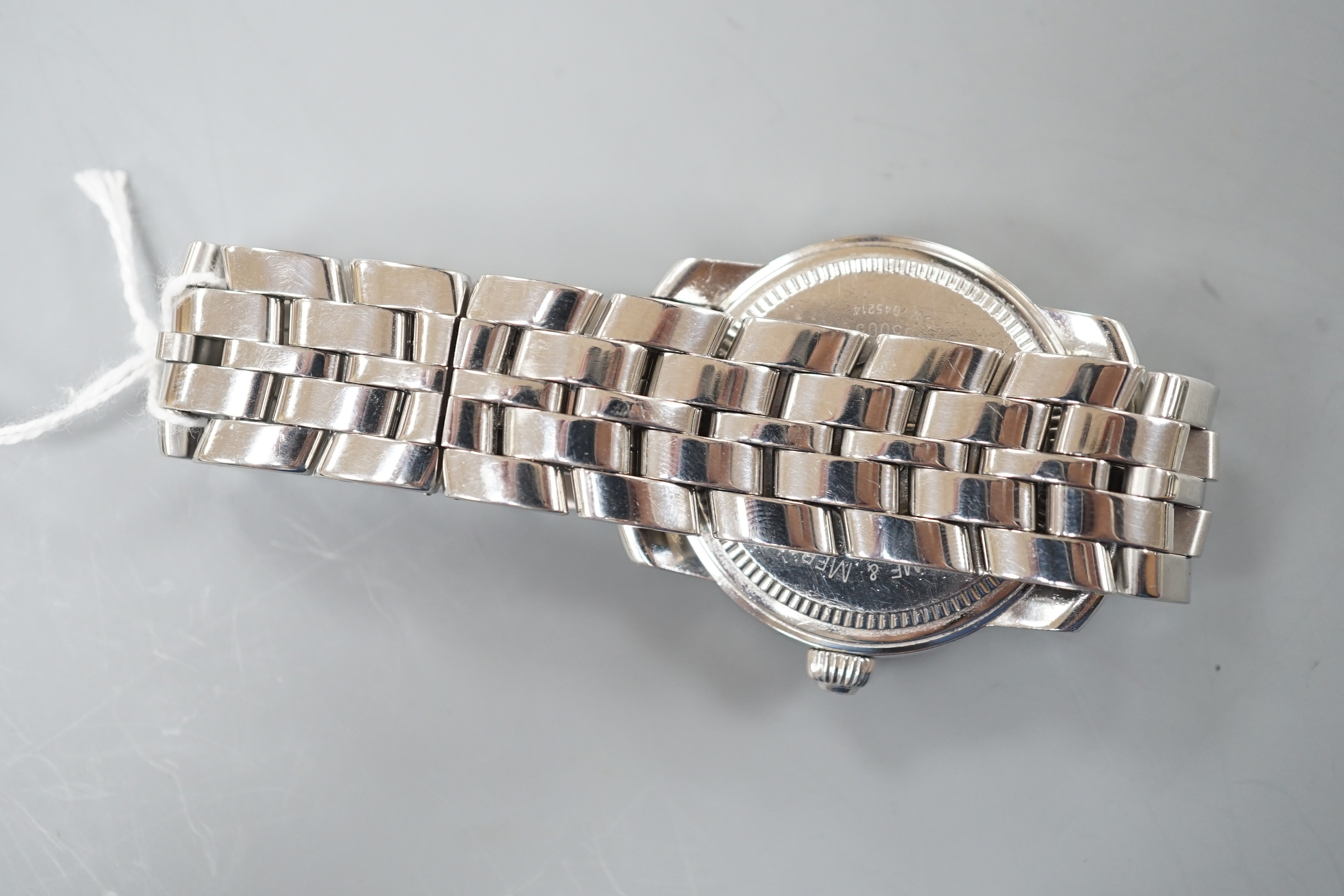 A gentleman's stainless steel Baume & Mercier quartz wrist watch, with black Arabic dial and date aperture, case diameter 37mm, with spare links, no box or papers.